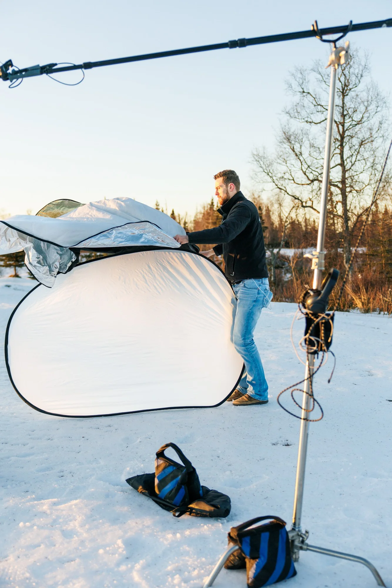 Professional softbox and lighting stand set up in deep Alaskan snow for winter commercial shoot